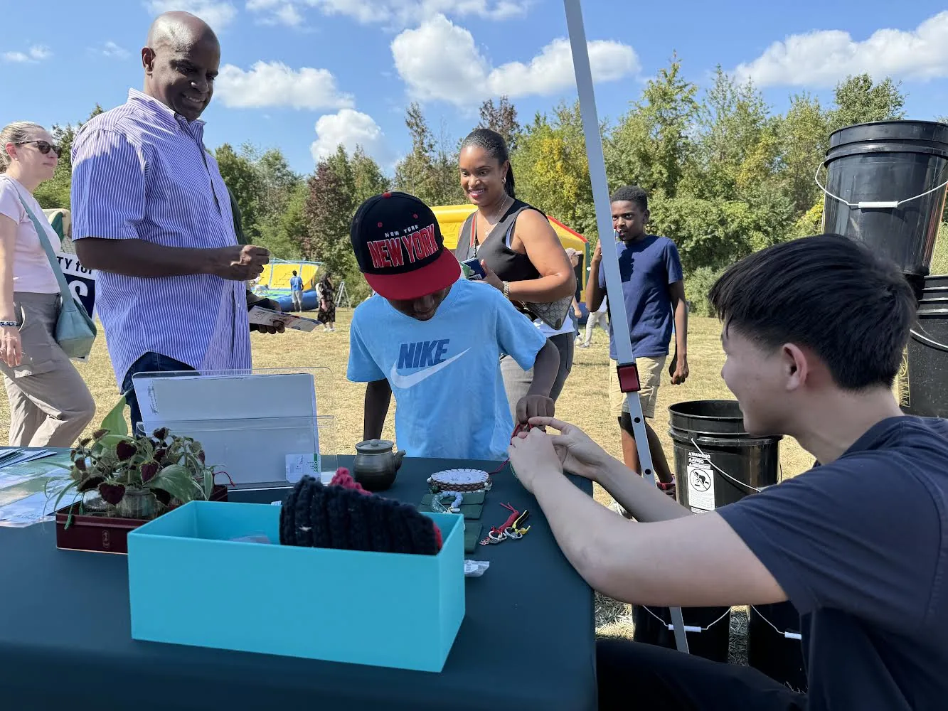 A Torus student volunteer engaging with families at a West Windsor community event.