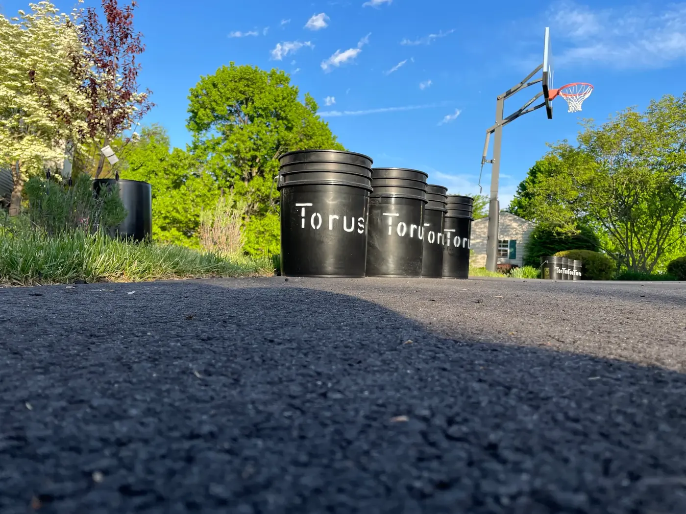 A row of Torus compost buckets lined up, representing scraps pooled by a neighborhood.
