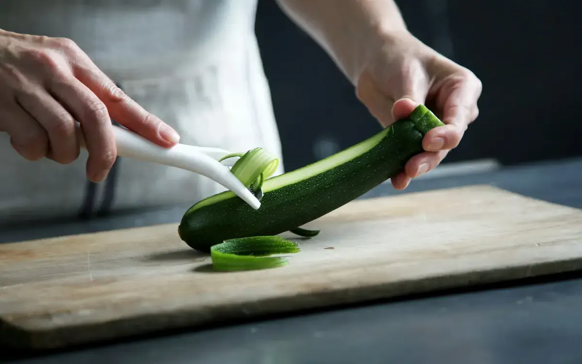 A person preparing fresh vegetables in a home kitchen