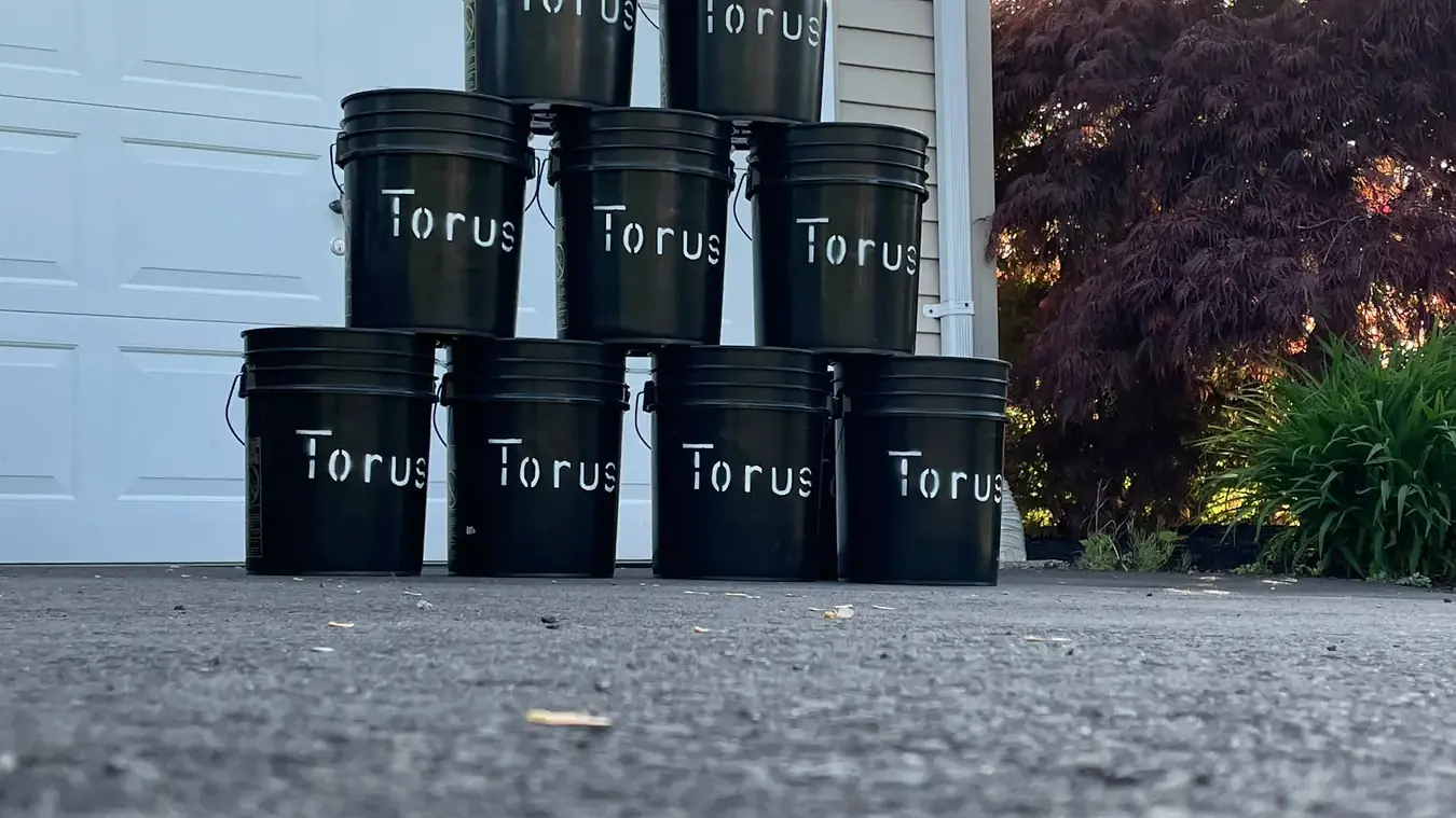 Torus food-scrap buckets stacked for collection from households, restaurants, and organizations.