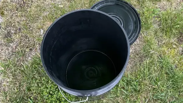 Top-down view of a clean, sealed Torus bucket at a door, showing composting is tidy and odor-free.